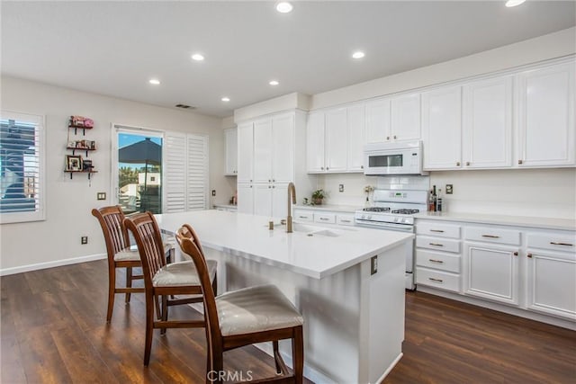 kitchen featuring white cabinets, white appliances, and sink