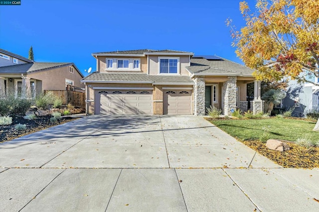 view of front of property featuring solar panels, a garage, and a front yard