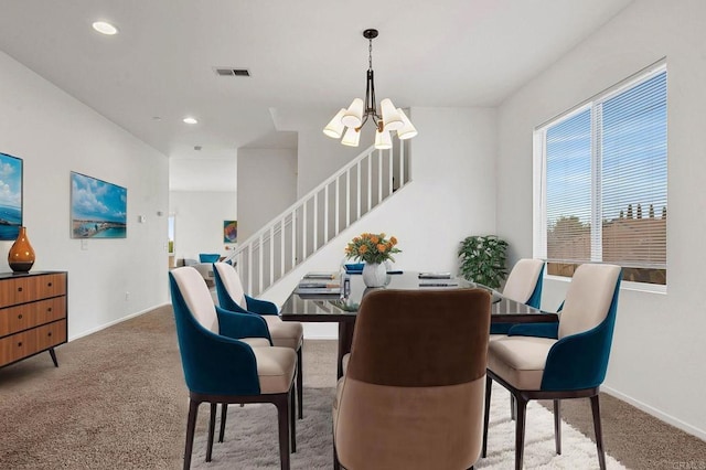 carpeted dining space with a notable chandelier