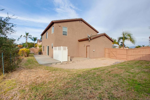 rear view of house with a patio area and a lawn