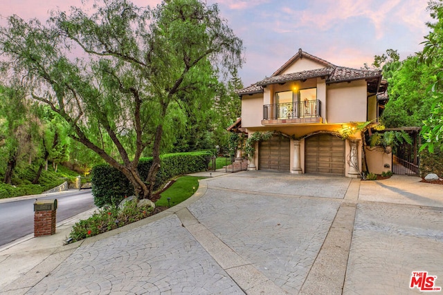 mediterranean / spanish-style home featuring a balcony and a garage