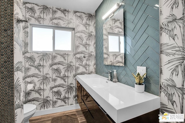 bathroom featuring plenty of natural light, toilet, wood-type flooring, and sink