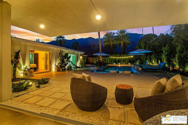 patio terrace at dusk featuring a mountain view