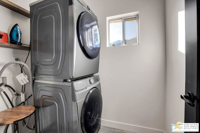 clothes washing area with hardwood / wood-style flooring and stacked washer and dryer