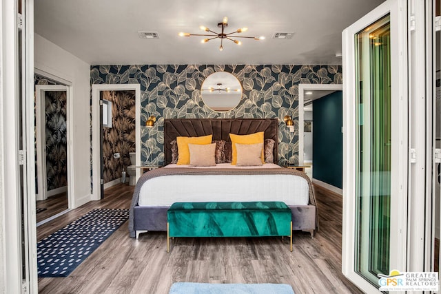 bedroom with hardwood / wood-style flooring and a notable chandelier