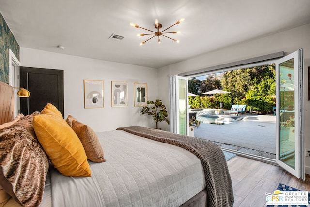 bedroom featuring access to outside, an inviting chandelier, and light wood-type flooring