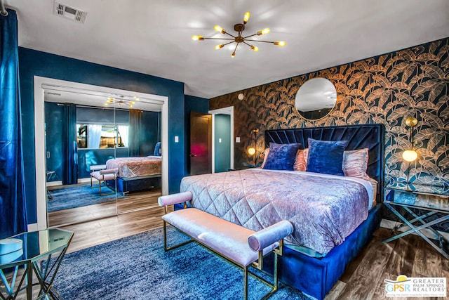 bedroom with hardwood / wood-style floors and a chandelier