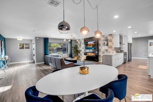 dining area featuring a fireplace and light hardwood / wood-style flooring