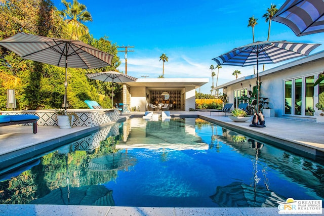 view of pool featuring a patio area and exterior fireplace