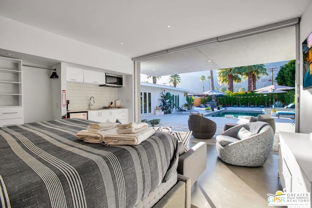 bedroom featuring floor to ceiling windows, concrete floors, sink, and multiple windows