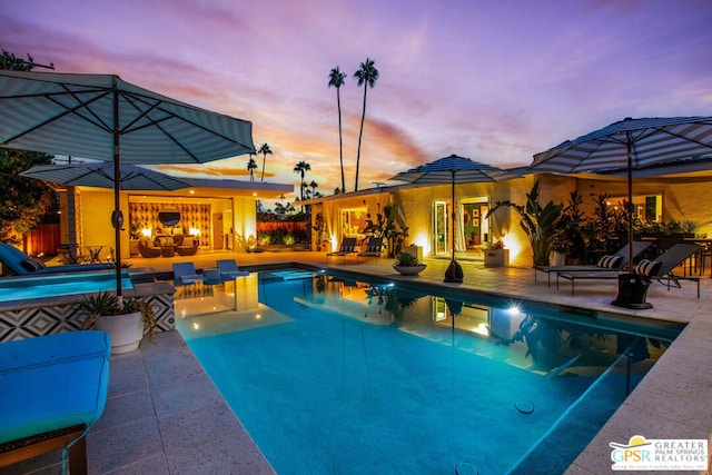 pool at dusk with a patio area