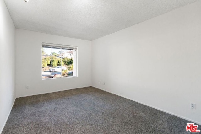 carpeted empty room with a textured ceiling