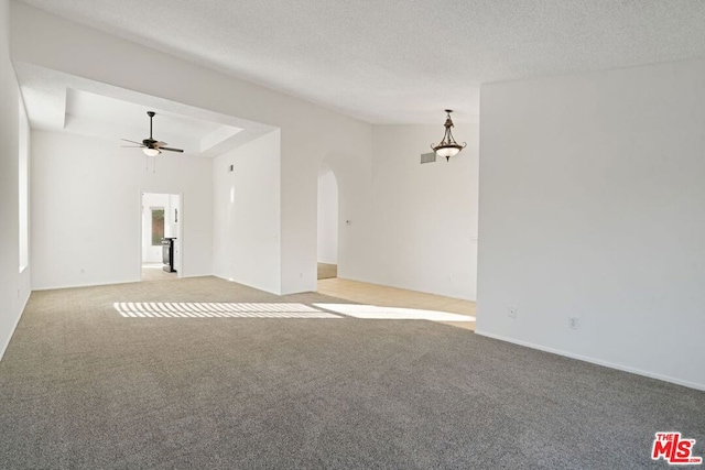 carpeted spare room featuring ceiling fan and a textured ceiling