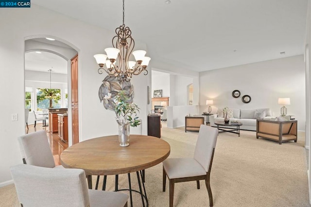 carpeted dining area with a chandelier