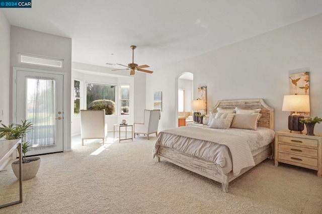 carpeted bedroom with access to exterior, ceiling fan, and multiple windows