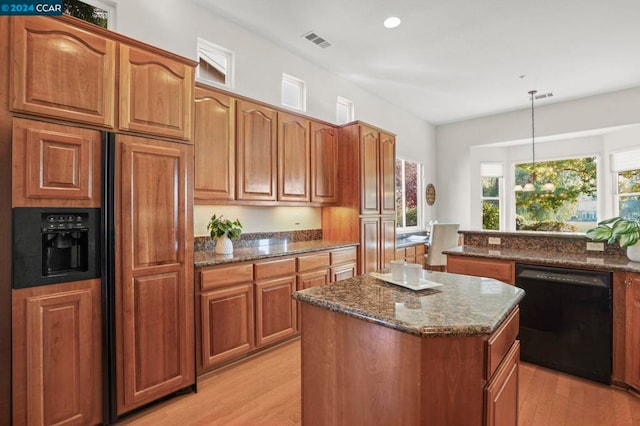 kitchen with light hardwood / wood-style flooring, a kitchen island, pendant lighting, and black dishwasher