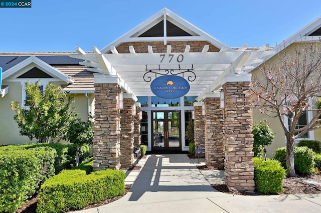 entrance to property with a pergola and french doors