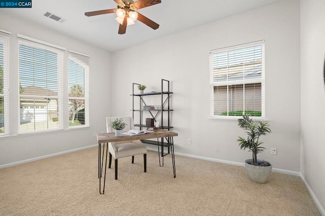 carpeted office featuring ceiling fan and a wealth of natural light