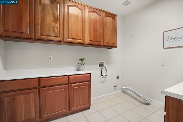 clothes washing area with cabinets, hookup for an electric dryer, gas dryer hookup, hookup for a washing machine, and light tile patterned floors