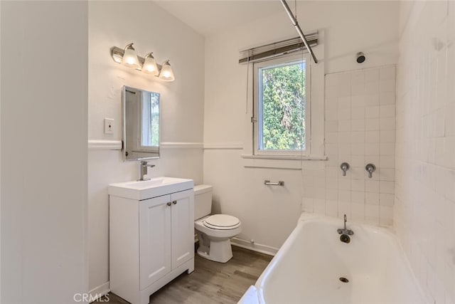 full bathroom featuring hardwood / wood-style flooring, vanity, toilet, and tiled shower / bath