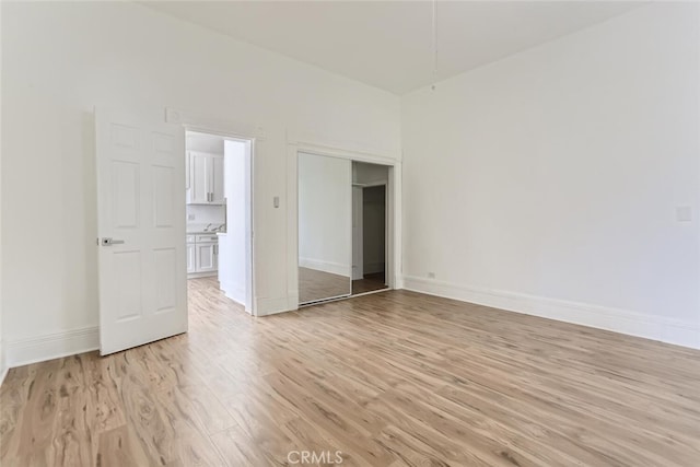 unfurnished bedroom with a closet and light hardwood / wood-style floors