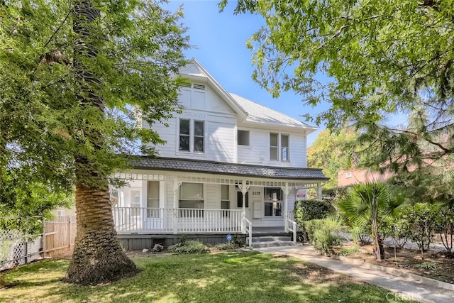 view of front of property with covered porch and a front yard