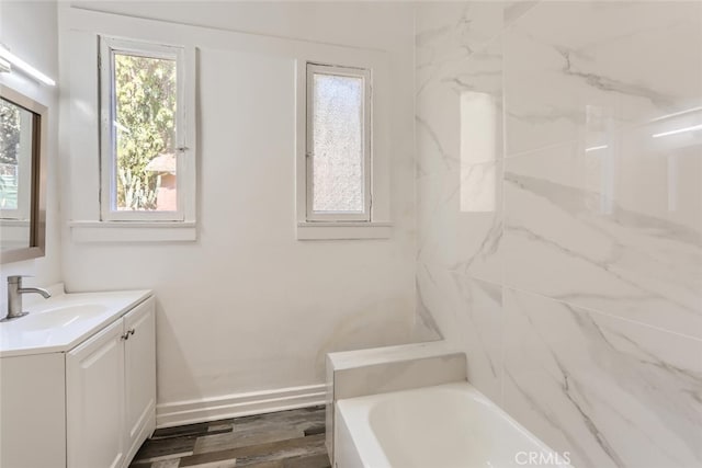 bathroom with vanity, wood-type flooring, and a tub to relax in