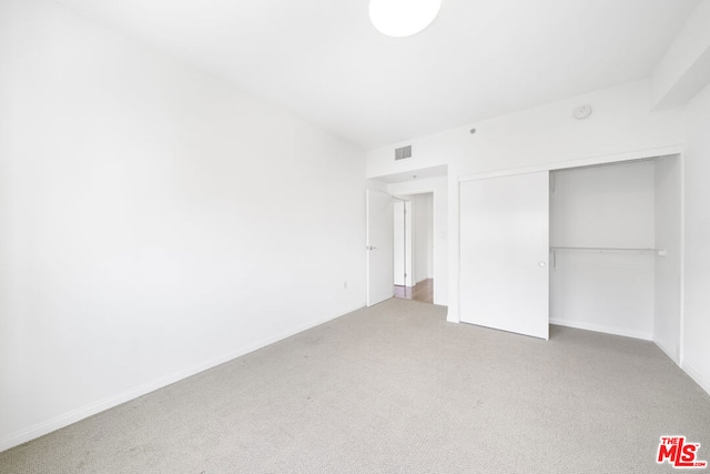 unfurnished bedroom featuring a closet and carpet floors