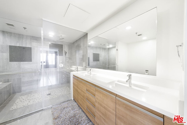 bathroom with vanity and a shower with door