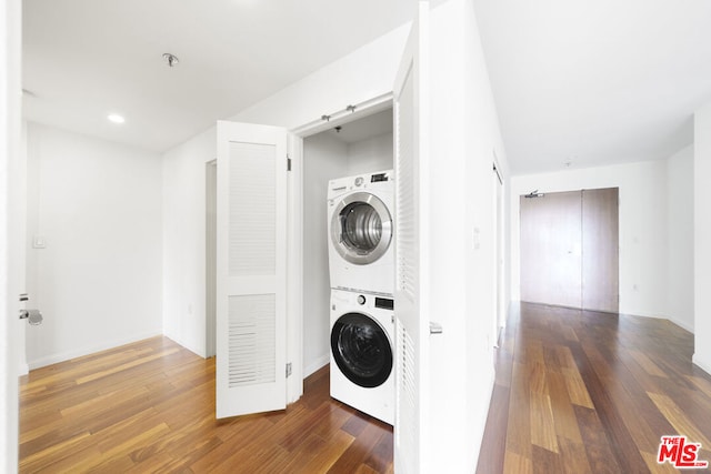 washroom featuring dark hardwood / wood-style flooring and stacked washer and dryer