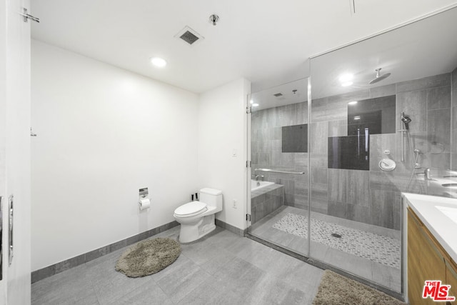 bathroom with a shower with door, vanity, and toilet