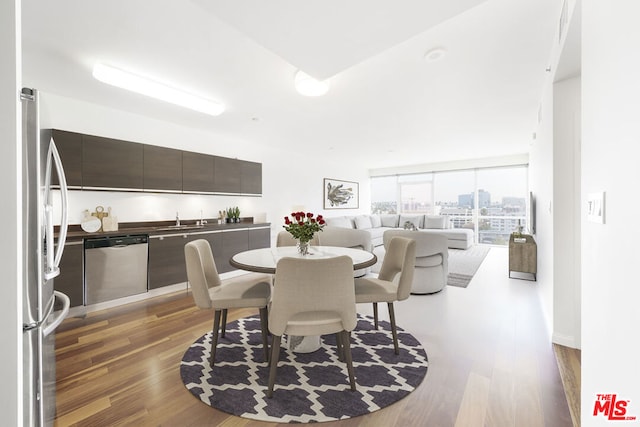 dining area with dark hardwood / wood-style flooring, expansive windows, and sink