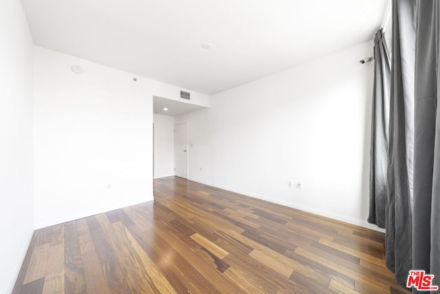 empty room with dark hardwood / wood-style flooring