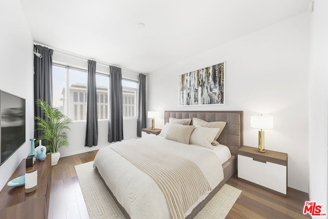 bedroom with dark hardwood / wood-style floors