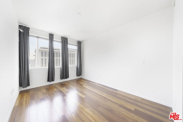 unfurnished room with dark wood-type flooring