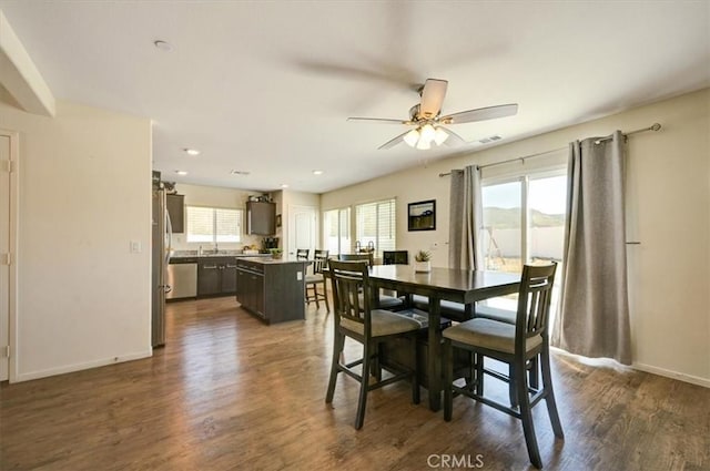 dining area with ceiling fan and dark wood-type flooring