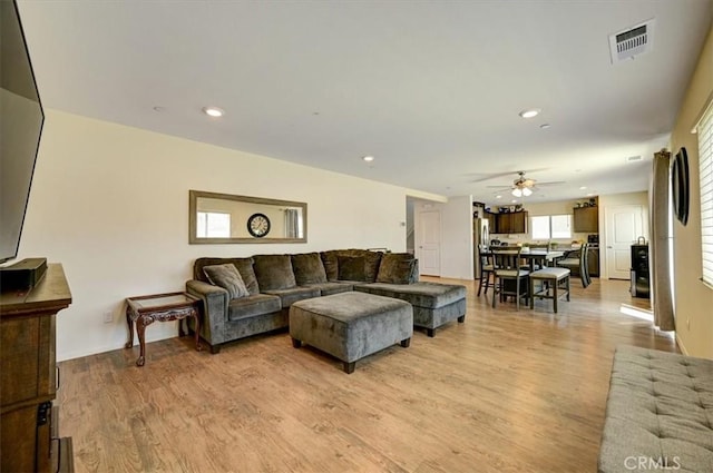 living room with ceiling fan and light wood-type flooring