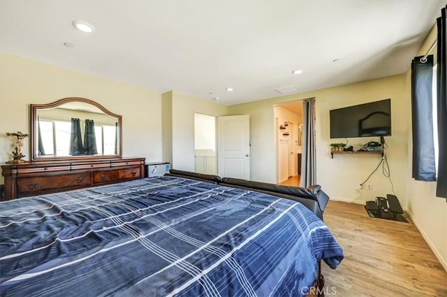 bedroom featuring wood-type flooring and connected bathroom