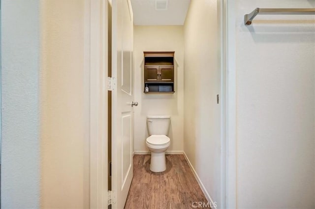 bathroom with wood-type flooring and toilet