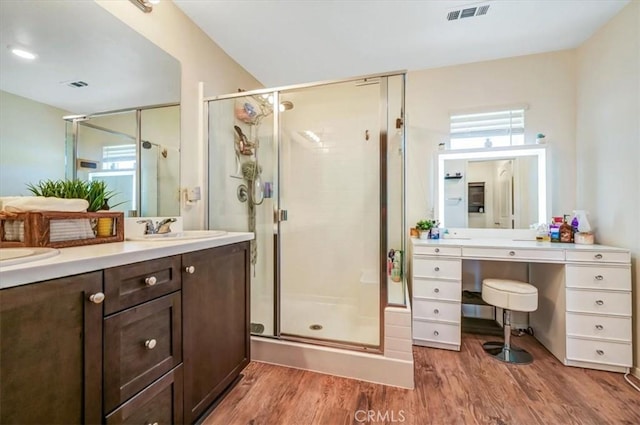 bathroom with wood-type flooring, vanity, and walk in shower