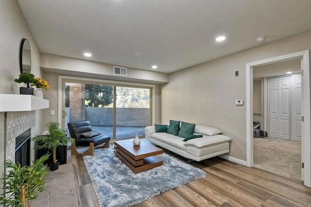 living room with light wood-type flooring and a fireplace