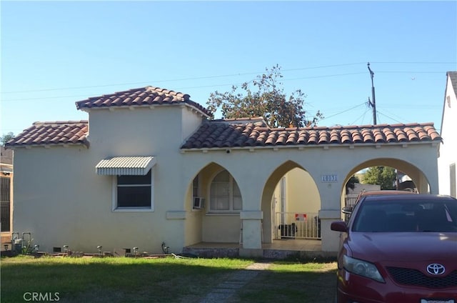 mediterranean / spanish-style home with covered porch and a front yard