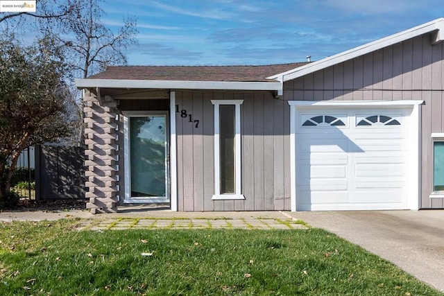 property entrance with a garage and a yard