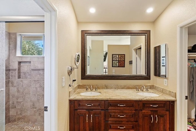 bathroom with vanity and a tile shower