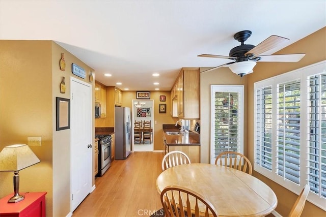 dining area featuring light hardwood / wood-style flooring, ceiling fan, and sink