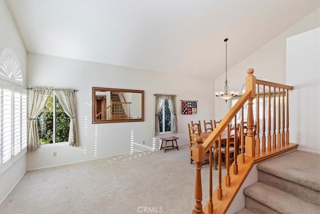 staircase featuring carpet floors, a chandelier, and lofted ceiling