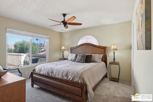 bedroom featuring light carpet, a textured ceiling, and ceiling fan