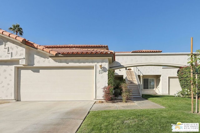 mediterranean / spanish home with a garage and a front lawn