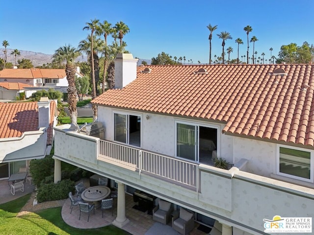 rear view of house with a patio area and a balcony