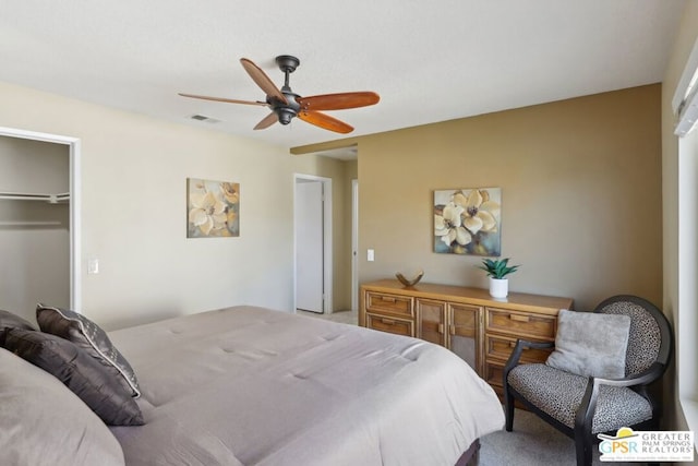 carpeted bedroom with ceiling fan, a closet, and a spacious closet